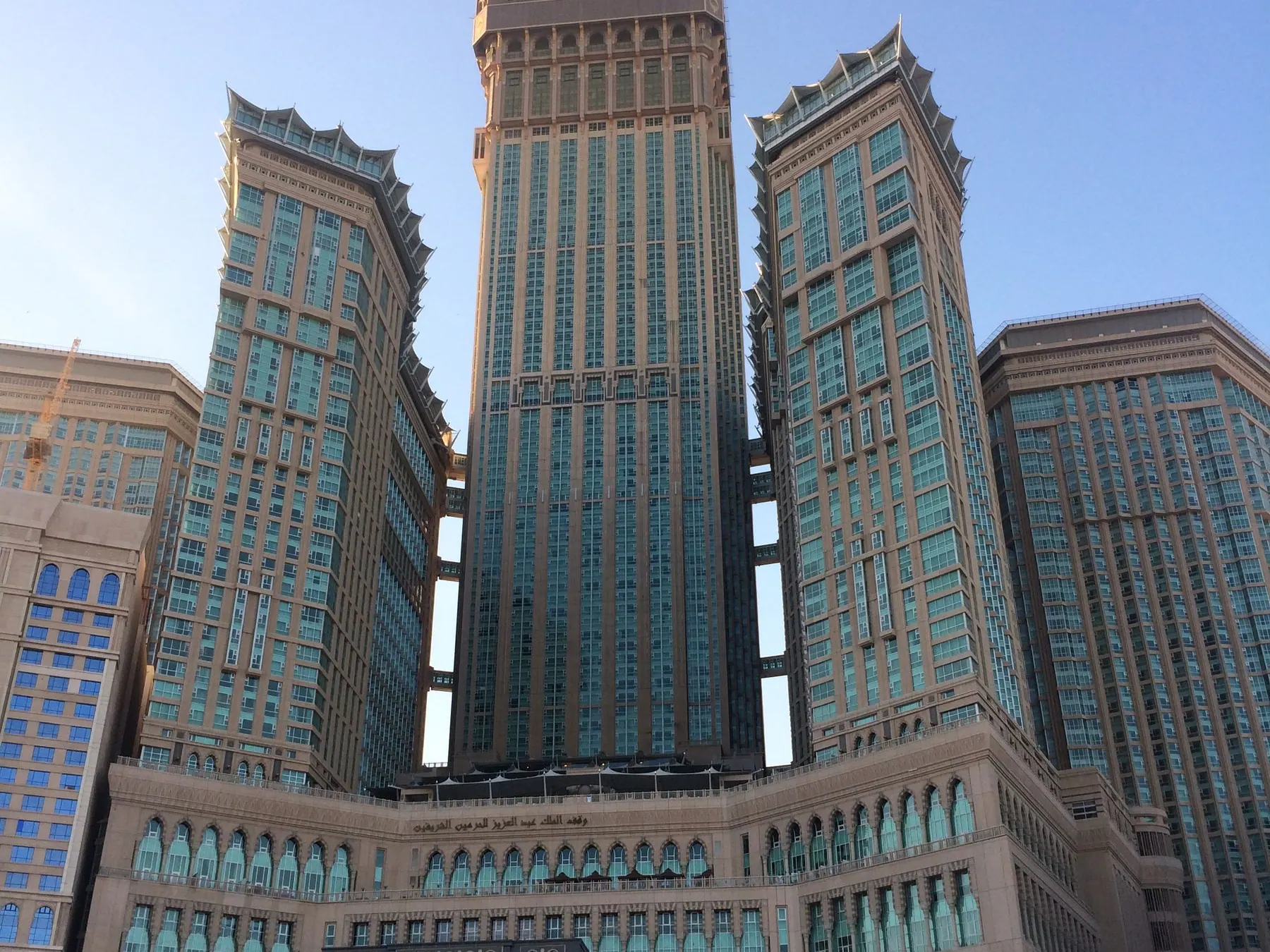 Modern towers rising above Makkah under a blue sky